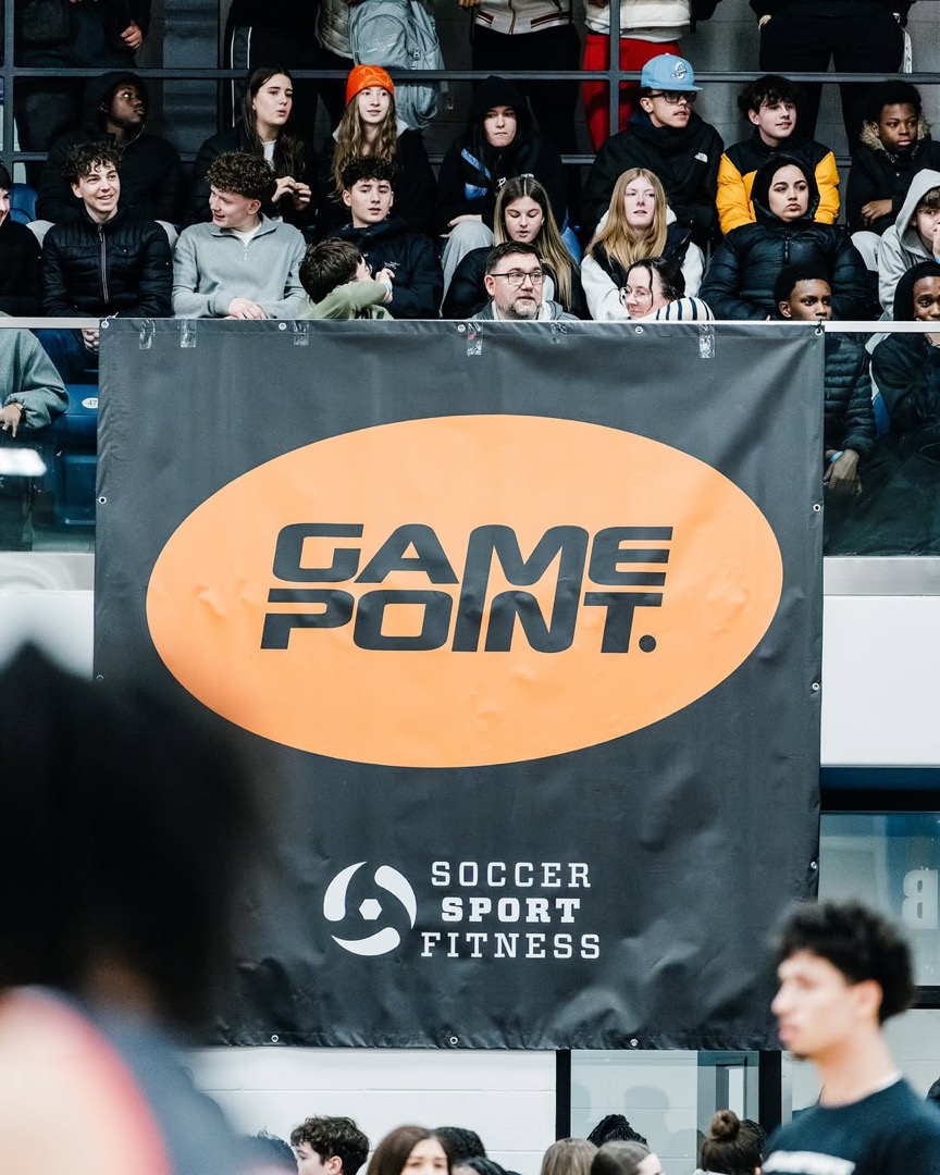 Couverture médiatique Game Point — bannière dans le gymnase, foule en tribune lors d'un événement